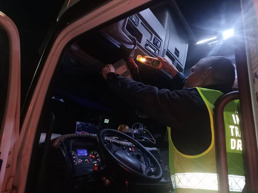 Inspektor ITD sprawdza tachograf w ciężarówce.